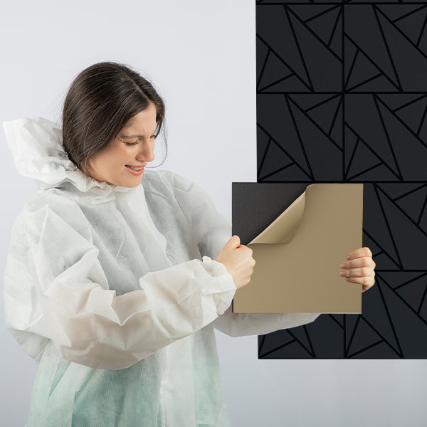 Woman in a protective gown holding a geometric sound proofing panels patterned wall panel.